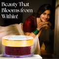 Woman in traditional attire with a jar of red cream labeled 'Beauty That Blooms from Within'.